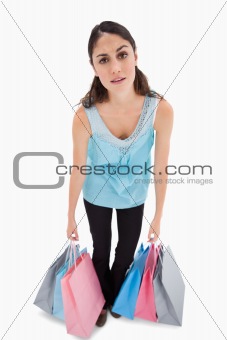 Portrait of a tired woman posing with shopping bags