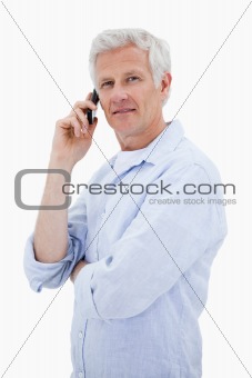 Portrait of a mature man making a phone call while looking at the camera