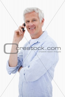 Portrait of a happy man making a phone call while looking at the camera