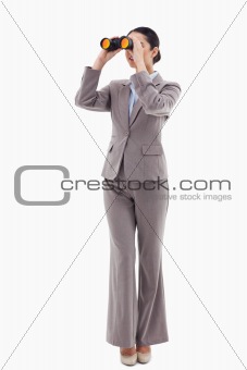 Portrait of a brunette businesswoman looking through binoculars