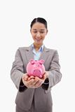Portrait of a happy businesswoman holding a piggy bank