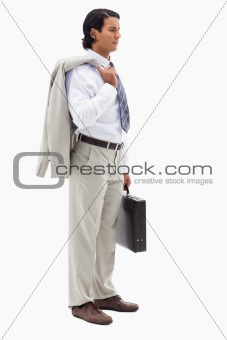 Portrait of a serious office worker holding his jacket over his shoulder and a briefcase