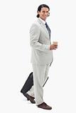 Side view of businessman with coffee and wheely bag