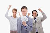 Businessman with cheering colleagues and money
