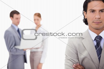 Businessman with colleagues with laptop behind him