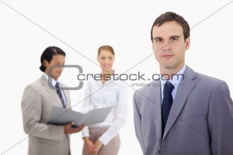 Young businessman with colleagues behind him