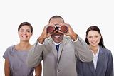 Businessman with colleagues looking through binoculars