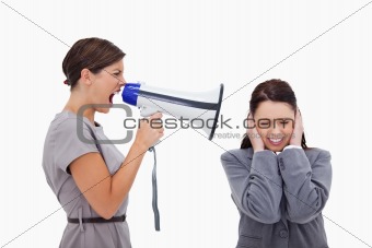 Businesswoman yelling at colleague with megaphone