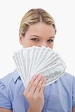 Woman hiding her face behind money