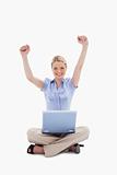 Woman with laptop raising her hands