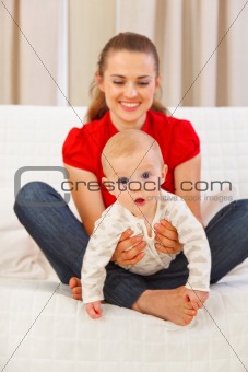 Interested baby playing on mothers laps
