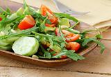 salad with arugula and cherry tomatoes on a wooden plate