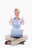 Sitting woman with laptop giving thumbs up