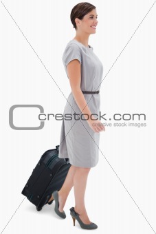 Side view of woman with wheely bag