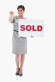 Woman with sold sign handing over key
