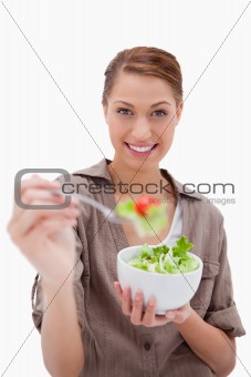 Woman with bowl of salad offering some