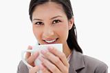 Smiling businesswoman holding cup close