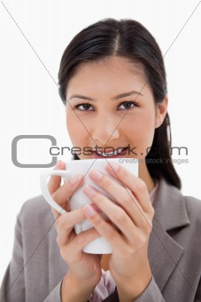 Businesswoman holding cup with both hands