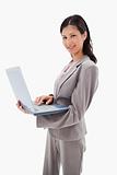 Side view of smiling businesswoman standing with laptop