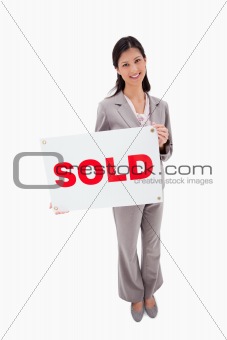 Real estate agent with sold sign