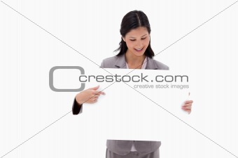 Businesswoman looking and pointing at blank sign board
