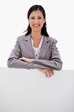 Smiling businesswoman leaning on blank wall