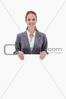Smiling bank employee holding blank sign in her hands