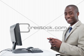 Smiling businessman sending a text message