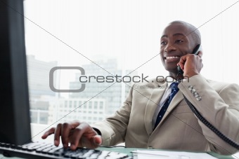 Businessman on the phone while using a computer