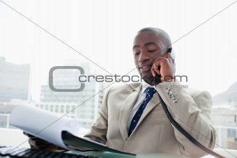 Businessman on the phone while reading a document