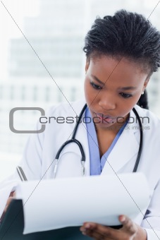 Portrait of a young female doctor signing a document