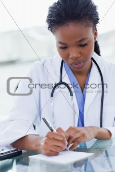 Portrait of a female doctor writing a prescription