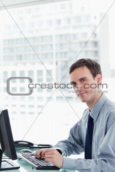 Side view of a serious office worker using a monitor