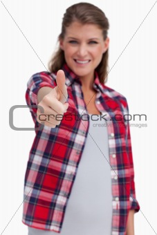 Portrait of a young woman with the thumb up