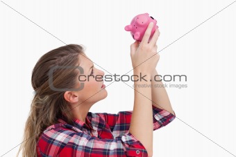 Woman looking inside a piggy bank