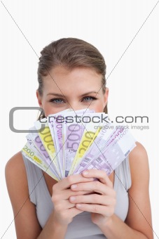 Portrait of a happy woman smelling bank notes