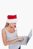 Woman with a Christmas hat using a laptop