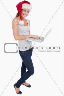 Portrait of a woman with a Christmas hat using a laptop