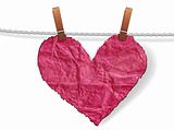 Crumpled  ragged heart attached to a clothesline with pin