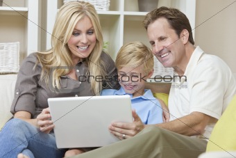 Happy Family Sitting on Sofa Using Laptop Computer