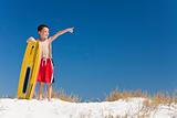 Young Boy Child on A Beach with Surfboard Pointing