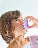 girl using an inhaler for asthma