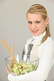 Woman carrying bowl of salad on white background