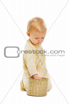 Interested baby checking inside of basket isolated on white