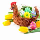 easter eggs in basket with yellow tulip flowers