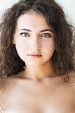 Portrait of a beautiful young brunette with curly hair
