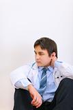 Tired medical doctor sitting on floor