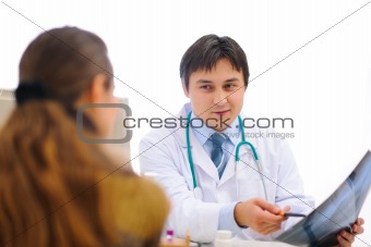 Smiling medical doctor showing roentgen to patient