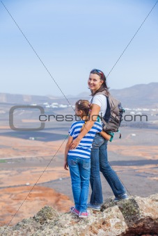 Mother and daughter standing on cliff's edge