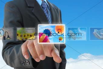 businessman hand pushing a button streaming images on a touch screen interface